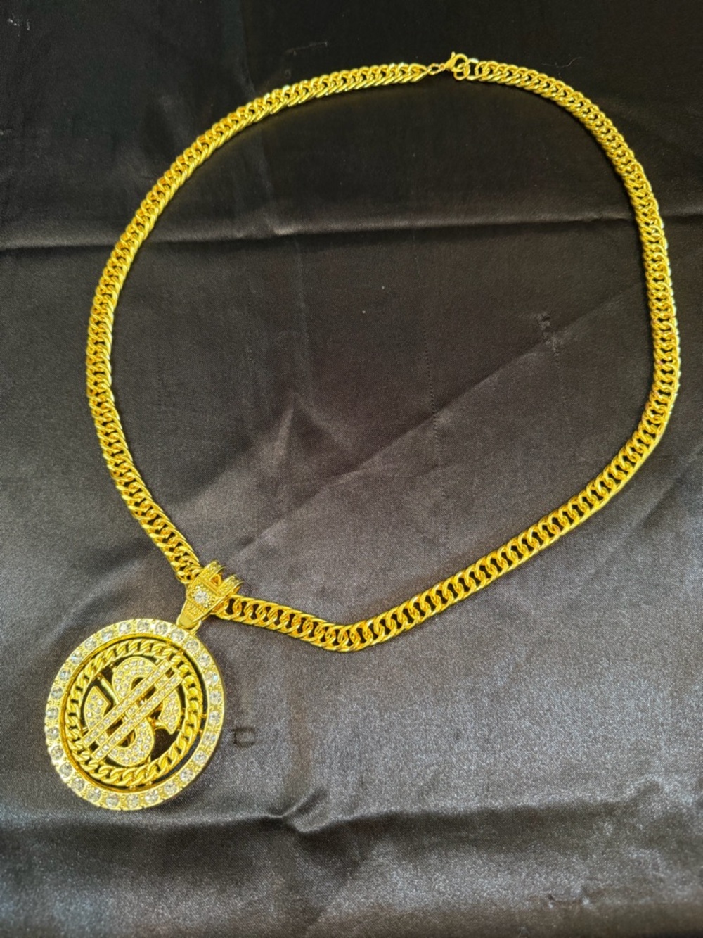 Gold tone chain revolving dollar logo necklace